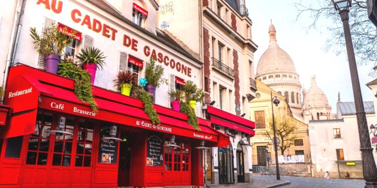 restaurant montmatres au cadet de gascogne, and view of the sacré coeur basilica in the background