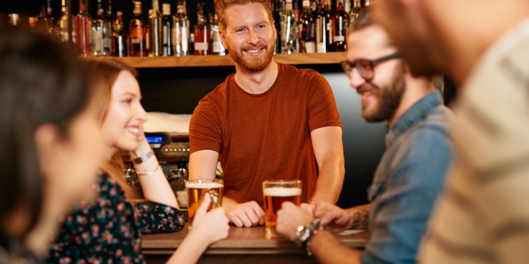 Group of friends drinking beer and chatting at an Irish pub